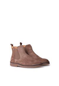 Bottines Chelsea en daim marron avec des panneaux élastiques sur les côtés, des languettes de tirage et une semelle en caoutchouc contrastante à coutures. Caractérisées par une texture lisse et mate.