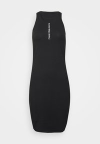 Svart ärmlös bodycon klänning i mjukt tyg. Har en böjd fåll och vit vertikal text som står "Calvin Klein Jeans" på framsidan.