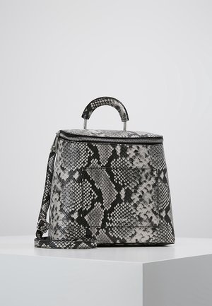 Sac à main structuré avec motif peau de serpent noir et gris, poignée supérieure, fermeture éclair et bandoulière réglable sur une surface blanche.