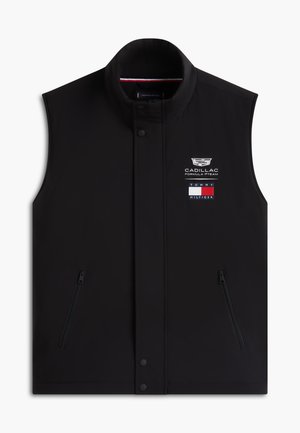 Gilet noir sans manches avec poches zippées, boutons-pression, logo de l'équipe Cadillac Formula 1 et drapeau Tommy Hilfiger sur la poitrine.