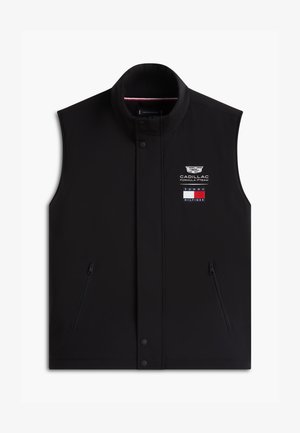 Gilet noir sans manches avec poches zippées, boutons-pression, logo de l'équipe Cadillac Formula 1 et drapeau Tommy Hilfiger sur la poitrine.