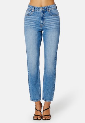 Hoge taille blauwe denim jeans met een rechte pijp, lichte wassing en subtiele vervaging. Beschikt over een klassiek vijfzakjesontwerp met messing hardware.