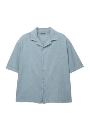 Chemise à manches courtes bleu clair avec une patte de boutonnage et un col en V. Fabriquée dans un tissu doux avec une texture subtile et une coupe décontractée.