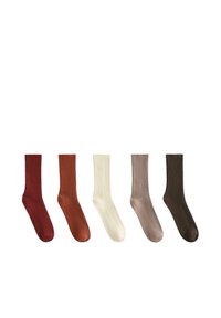 Cinq paires de chaussettes côtelées dans des tons de rouge foncé, rouille, crème, taupe et brun foncé, présentant une texture lisse et une forme classique de chaussette.