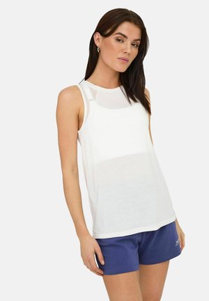 Witte mouwloze sporttanktop met een ronde halslijn en een ontspannen pasvorm, gecombineerd met blauwe shorts. Gladde textuur, minimalistisch ontwerp.