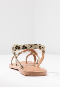 Žabky s leopardím potiskem, s texturovaným chlupatým svrchním dílem, hnědou koženou stélkou a zlatou kovovou sponou na pásku.