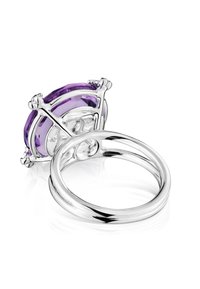 Srebrny pierścionek z dużym owalnym fioletowym kamieniem szlachetnym, z ustawieniem na ząbkach, gładką obrączką oraz misternymi detalami na krawędziach kamienia.