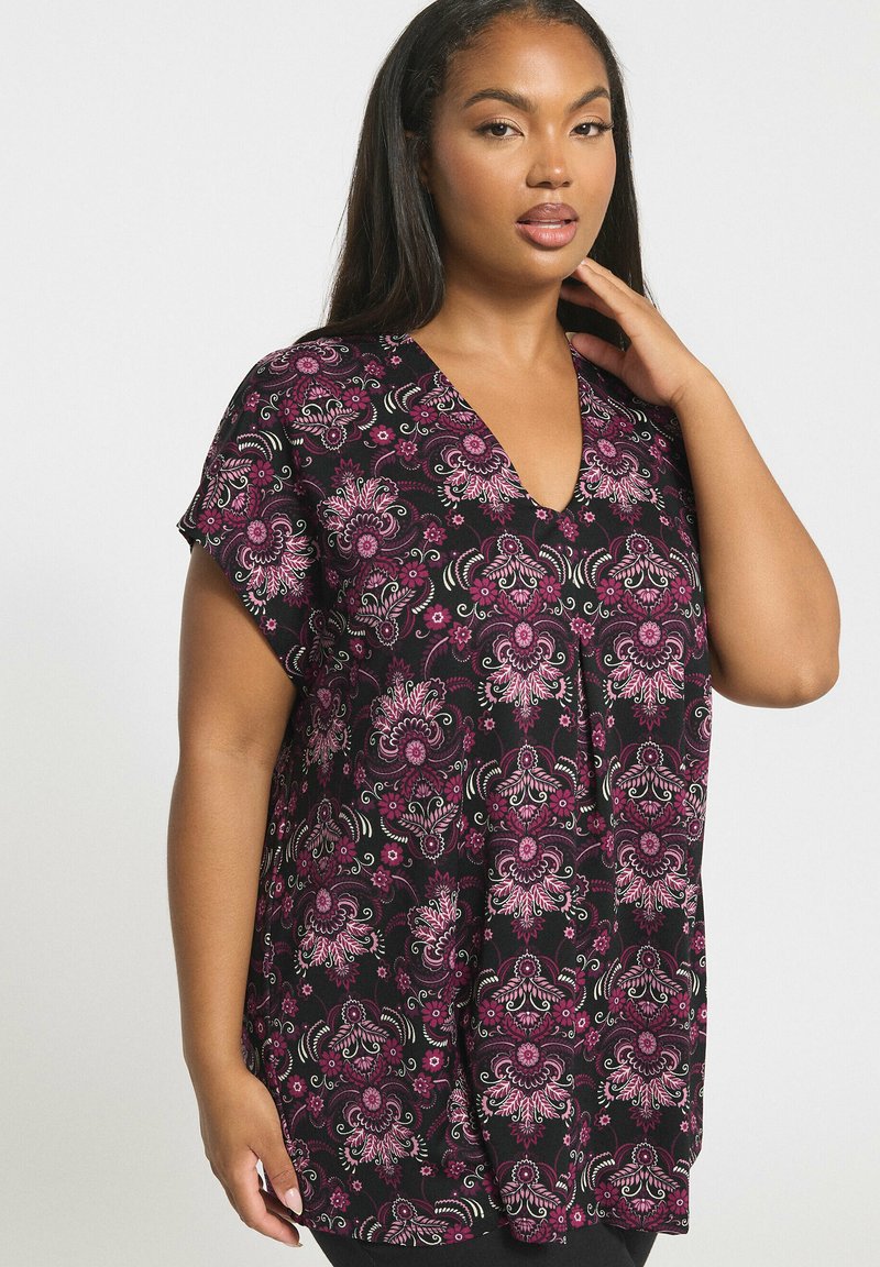 Svart tunika med ett livfullt rosa blommönster, V-ringad design, korta ärmar och lös passform. Mjuk, lätt tygkänsla.