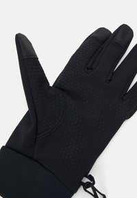 Sorte hansker laget av elastisk materiale har teksturert grep på fingrene, perforert design over håndflaten, og elastisk mansjett for sikker passform.