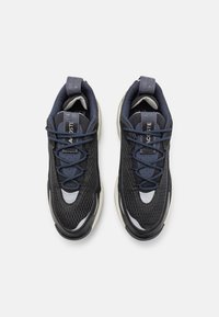 Baskets de course noires et marine avec tige en mesh, col rembourré et accents gris. Dotées de lacets plats et d'une semelle texturée pour une meilleure traction.