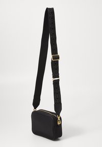 Borsa a tracolla nera rettangolare con una texture liscia, hardware in metallo dorato e una tracolla nera a motivo. Progettata per versatilità e funzionalità.