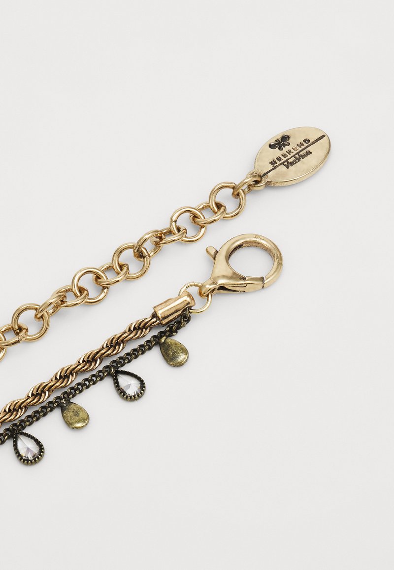 Pulsera de tono dorado con una mezcla de estilos de cadena; presenta gemas en forma de lágrima y un cierre de langosta, marcado con "Weekend". Diseño texturizado y en capas.