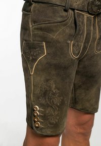 Lederhosen in dunkelolivgrün mit dekorativer Raffung und einer Seitentasche. Mit vier Knopfakzenten am Saum.
