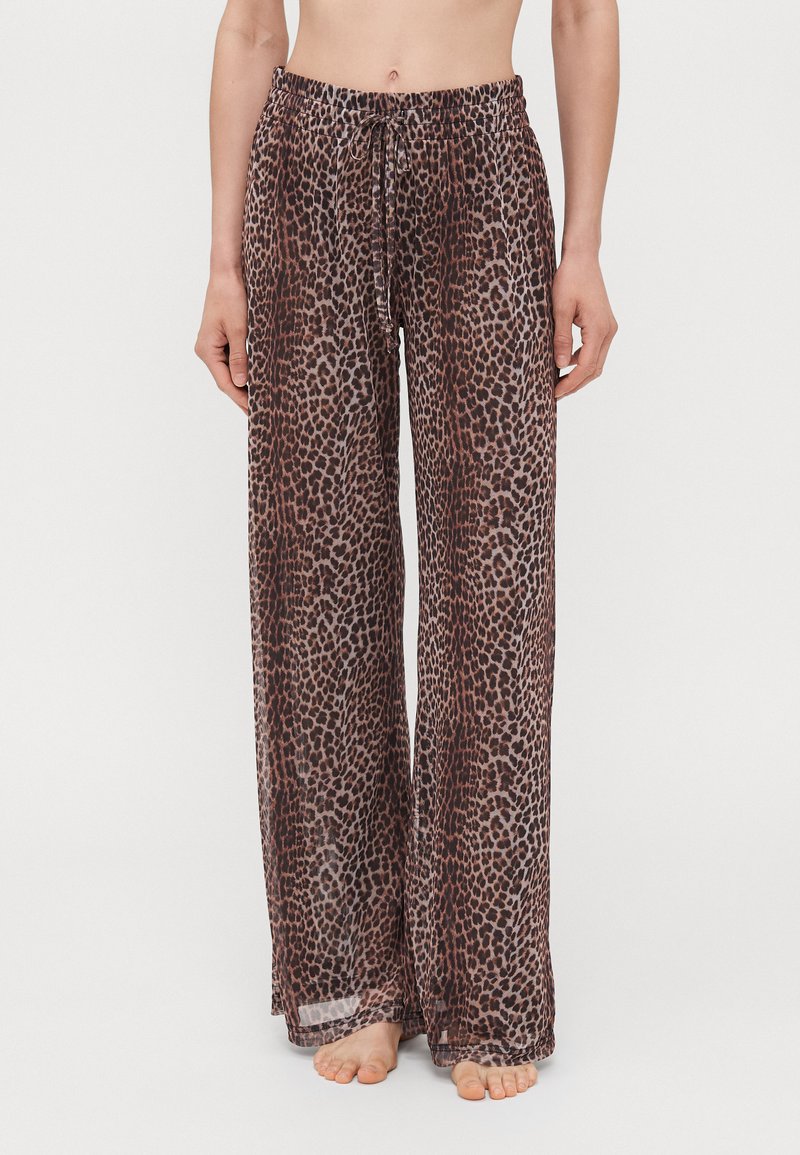 Lightweight, loose-fitting beige pants with a leopard print pattern, featuring an elastic waistband and drawstring for adjustable fit.