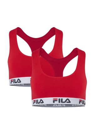 Dwa czerwone sportowe biustonosze FILA z krojem typu racerback oraz białe elastyczne paski z logo FILA w czarno-czerwonym kolorze.