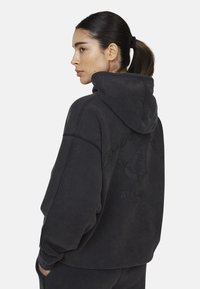 Felpa nera oversize con cappuccio, caratterizzata da una stampa grafica testurizzata di una farfalla e testo sul retro. Vestibilità rilassata e polsini a coste.