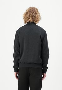 Dark gray sweatshirt with a high collar, ribbed cuffs, and waistband. Smooth fabric texture, featuring a simple design without patterns.