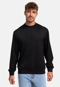 Sudadera negra de manga larga con cuello redondo, puños y dobladillo acanalados, hecha de un material suave, con una textura lisa y un diseño minimalista.