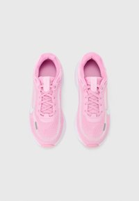 Par ružičastih laganih tenisica za trčanje s bijelim potplatima i vezicama, pogled odozgo na jednobojnoj pozadini.