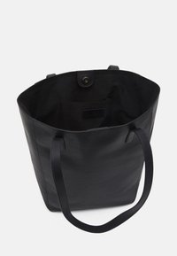 Zwarte leren shopper met een getextureerde afwerking, een ruim interieur en een magnetische kliksluiting. Voorzien van twee stevige handvatten.