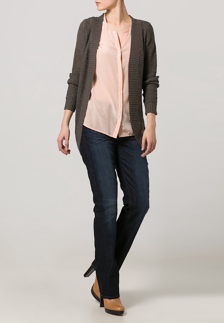 Gray knit cardigan over a light pink blouse, paired with dark blue jeans and tan heels. Cardigan features open front and long sleeves.