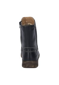 Bottines noires en cuir avec une finition lisse, fermeture éclair latérale, couture contrastante et semelle basse texturée. Intérieur doublé en tissu beige.