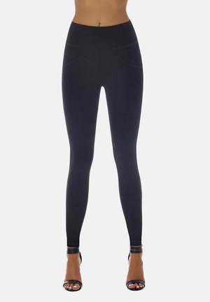 Czarne legginsy z wysokim stanem o gładkiej teksturze, z dwoma przednimi kieszeniami i dopasowanym krojem, w połączeniu z czarnymi sandałami na szpilce.