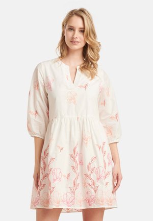 Witte jurk met roze bloemmotief, korte pofmouwen, V-hals en een geplooide taille, gemaakt van lichte stof.