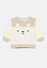 Beige og kremfarget genser med stripete tekstur. Har et bjørneansiktsdesign, rund hals og ribbestrikkede lange ermer.
