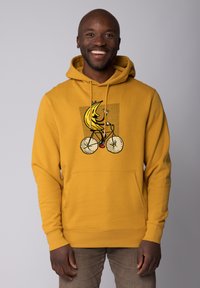 Gelber Hoodie mit einem vorderen Grafikdruck eines Cartoon-Bananas, die Fahrrad fährt. Mit einer Kängurutasche sowie gerippten Bündchen und Saum.
