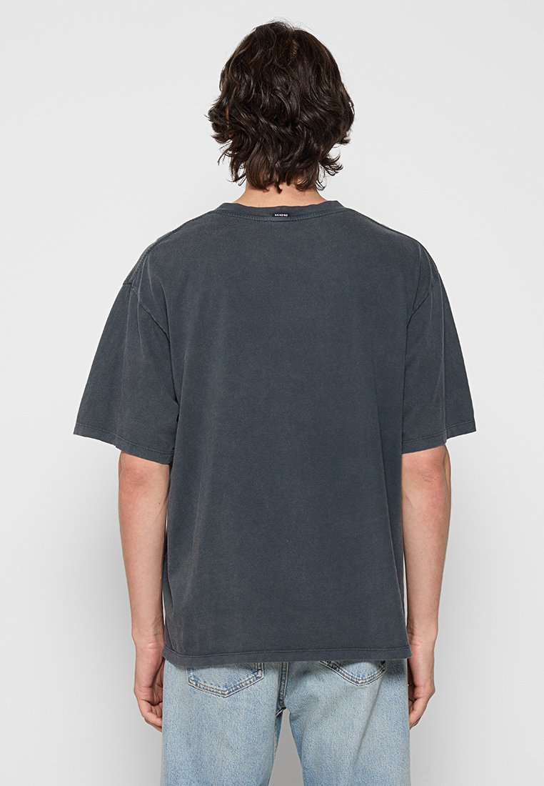 Dunkelgraues Baumwoll-T-Shirt mit kurzen Ärmeln, Rundhalsausschnitt und legerem Schnitt. Das Design auf der Rückseite zeigt ein einfaches Etikett am Hals. Leicht strukturiert.