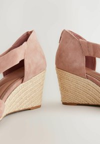 Sandali con zeppa caratterizzati da una tomaia in suede rosa chiaro, design con strappi incrociati e tacco in juta intrecciata. Soletta morbida con una finitura liscia.