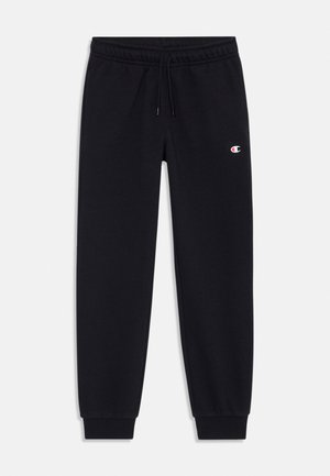 Pantalones de chándal negros hechos de un material suave, con una cinturilla elástica con cordón y puños acanalados. Pequeño logo en el muslo izquierdo.