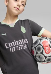 AC Milan futballmez sötétszürke színben, világos zöld kiegészítőkkel; tartalmazza a logót, a csapat nevét és a szponzor feliratot. Mintázott fekete és szürke focilabda.