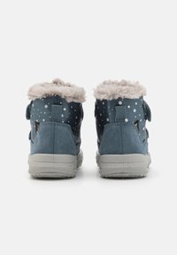 Blaue Knöchelstiefel mit einem weichen Fellkragen, im Punktenmuster, aus Wildleder und mit einer grauen Gummisohle für bessere Trittsicherheit.