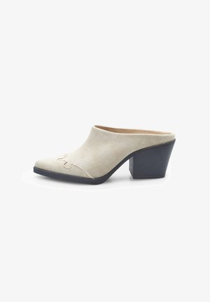 Beige fabric heeled mules with a pointed toe and texture. Black, textured block heel with subtle stitching detail on the upper.