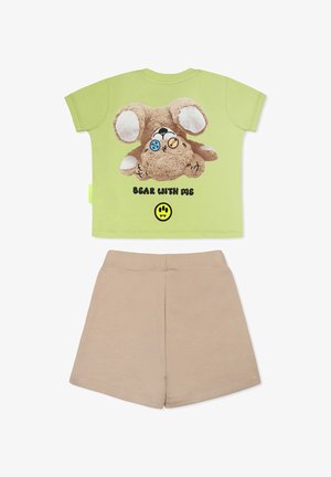 T-shirt in cotone verde chiaro con grafica di un orsetto peluche, testo "BEAR WITH ME" e pantaloni beigi. Presenta angoli arrotondati e maniche corte.