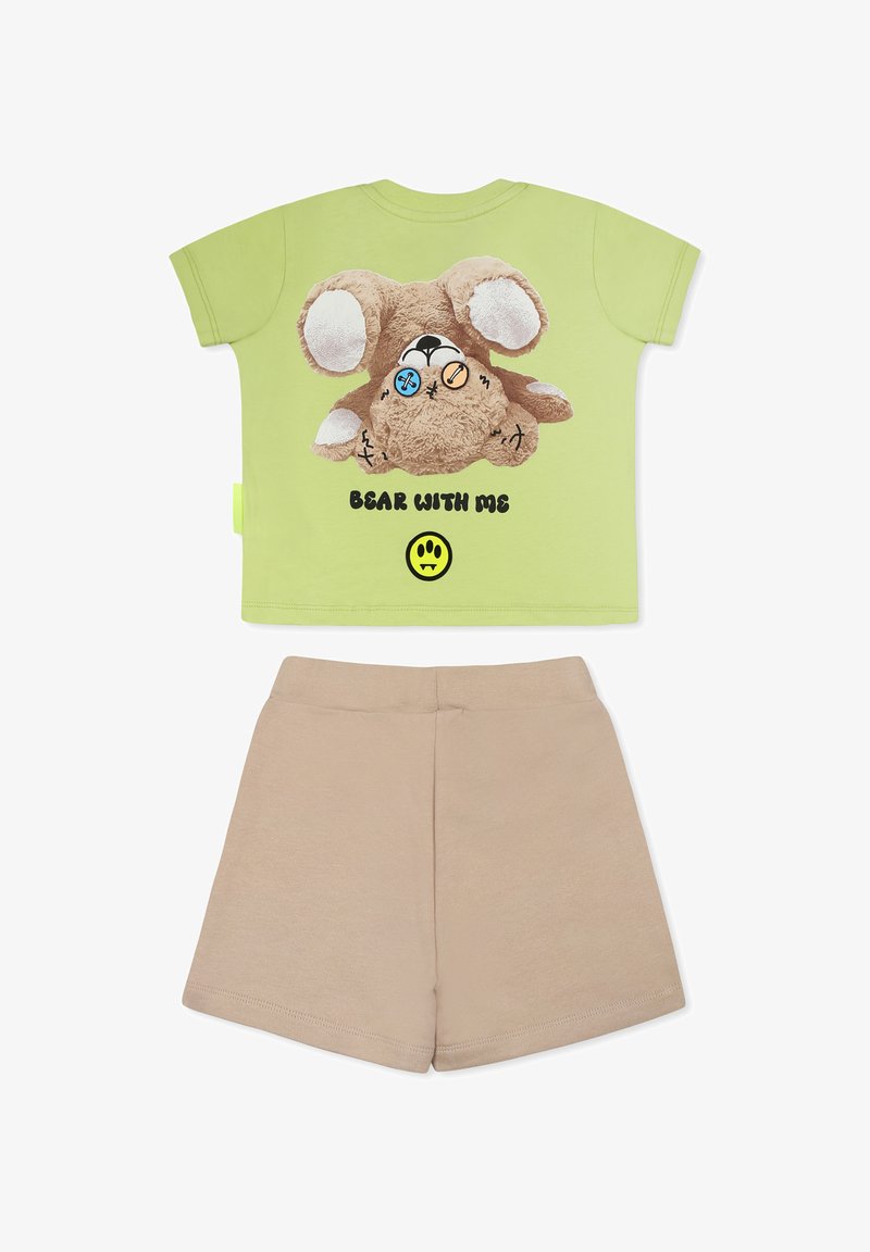 T-shirt in cotone verde chiaro con grafica di un orsetto peluche, testo "BEAR WITH ME" e pantaloni beigi. Presenta angoli arrotondati e maniche corte.