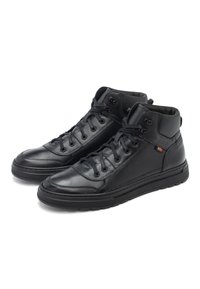 Zapatillas altas negras de cuero suave, con cordones planos, punta redonda, suelas de goma y un pequeño logotipo en el lateral.