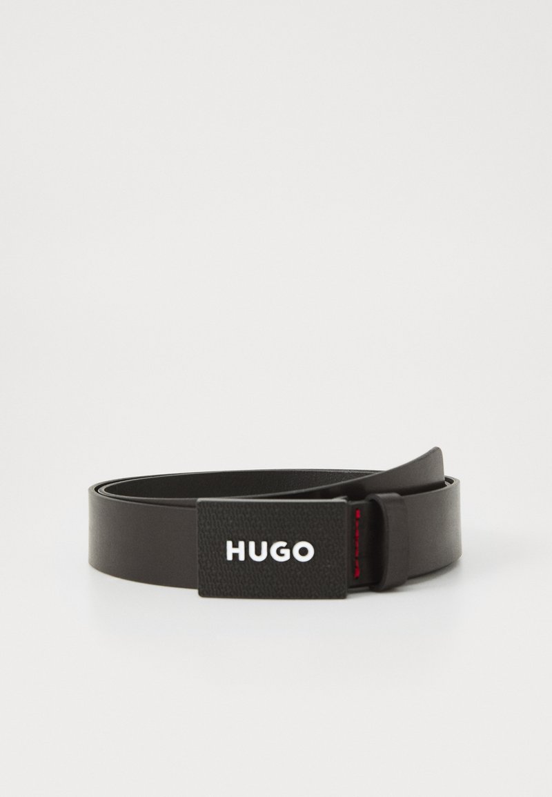 Czarny skórzany pasek z fakturowaną klamrą w czarno-białym kolorze, z logo "HUGO" i czerwonym akcentem.