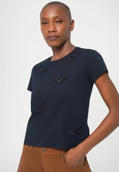 T-shirt bleu marine à manches courtes en coton, avec des accents noirs texturés en forme de lignes courbes sur le devant.