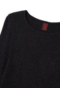 Zwarte geribbelde gebreide trui met een ronde halslijn en subtiele métallieke deeltjes. Rode label met merknaam zichtbaar bij de nek.