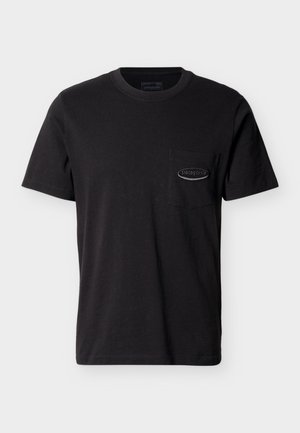 Must musta lühikeste varrukatega t-särk, millel on vasakul rinnal tasku, millel on väike ovaalne Patagonia logo pael.