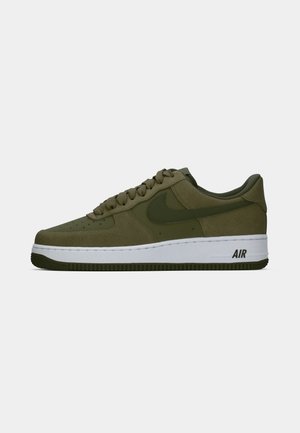 Gröna mockasneakers med en vit mellansula, med runda snören, perforerad tådel och svart AIR-logotyp på hälen.