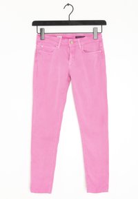 Jeans ajustados rosa con textura suave, cinco bolsillos y cierre de botón metálico. Suspendidos de una percha de plástico negra.