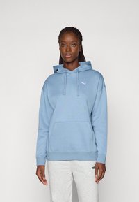 Light blue hoodie with a front pocket, drawstrings, and a small white Puma logo on the left chest. Soft fabric and relaxed fit.
