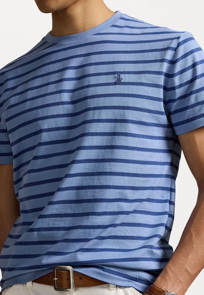 Tricou cu dungi albastre, cu dungi orizontale de culoare albastru închis, guler rotund, mâneci scurte, având un mic logo brodat pe piept.