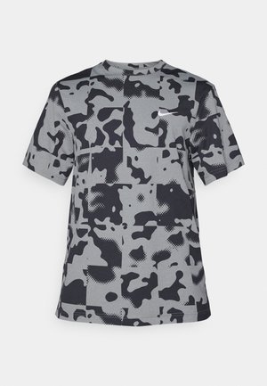 Szara koszulka z krótkim rękawem, ozdobiona czarnym wzorem w kamuflaż o różnych kształtach i fakturach. Okrągły dekolt, lekki materiał.