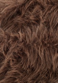 Close-up van zachte, dichte bruine vacht met fijne, flonkerige strengen die een gestructureerd, pluizig oppervlak creëren.