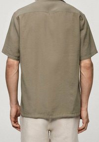 Korte mouwen, olijfgroen shirt gemaakt van zachte stof. Voorzien van een klassieke kraag en een rechte zoom, minimalistisch ontwerp zonder versieringen.